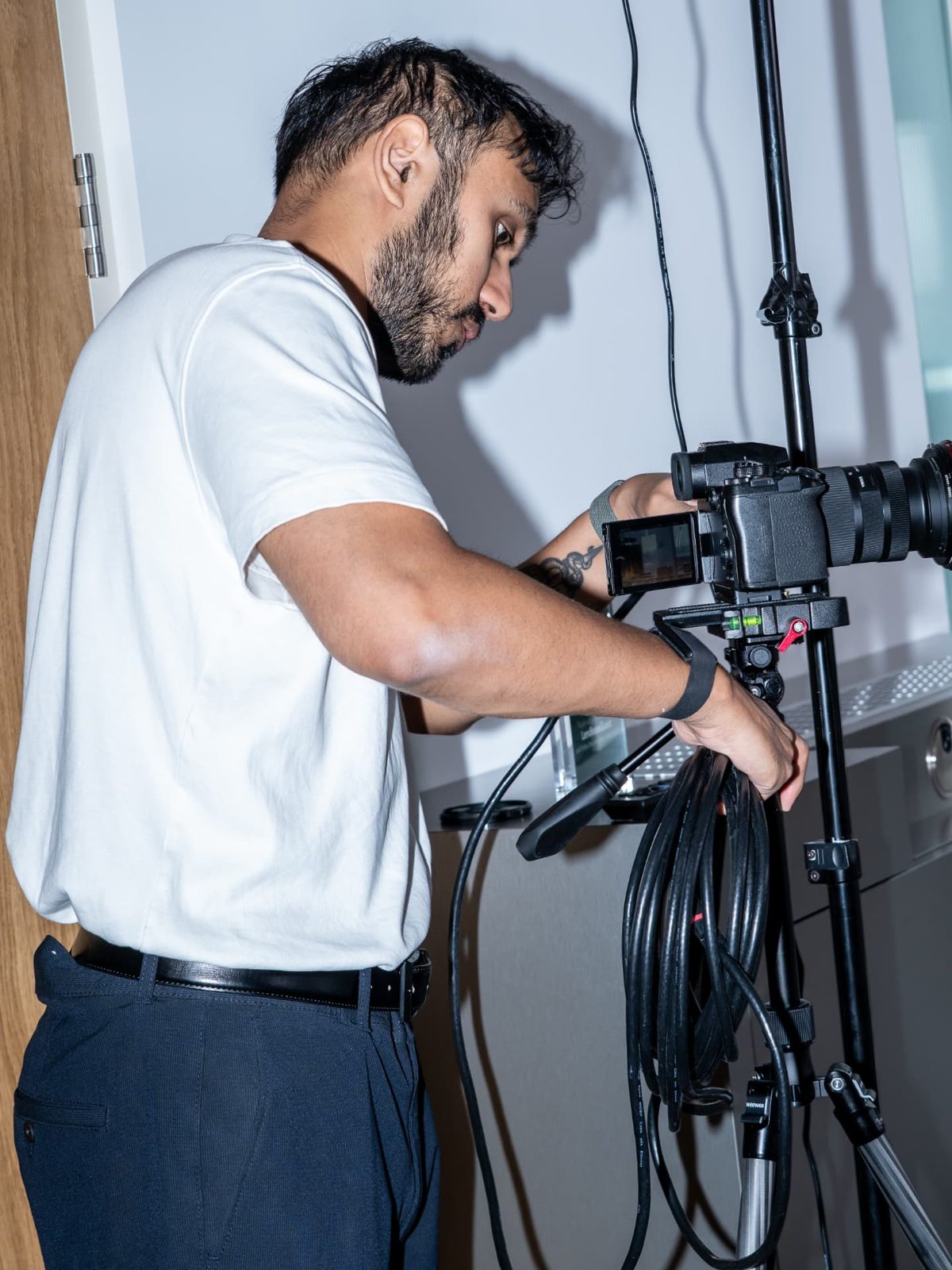 Operator rigging a camera and coiling cable before a shoot