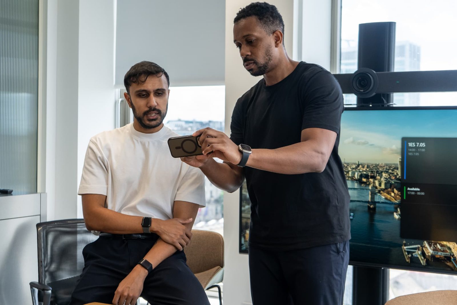 Producer and operator reviewing a shot on a phone between takes