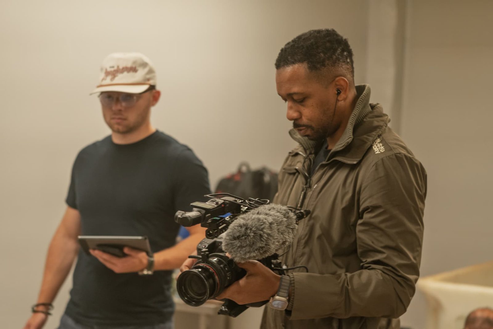 Camera operator filming handheld while a producer follows the run sheet